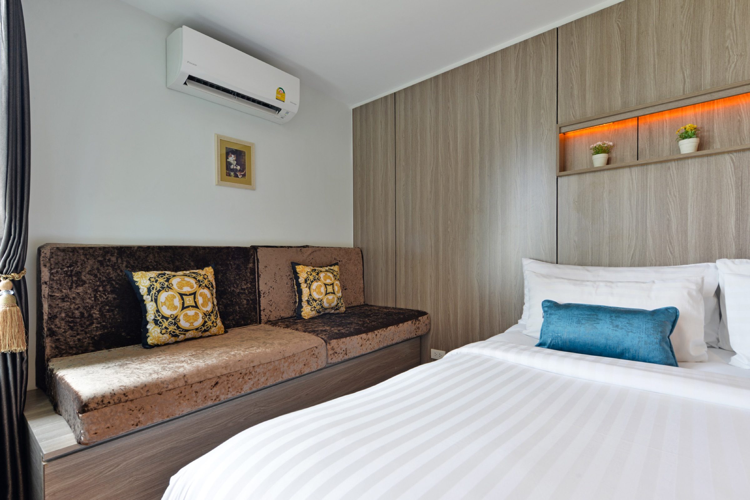 The sofa seating corner and king bed in a Deluxe King room at StayAt Bedever