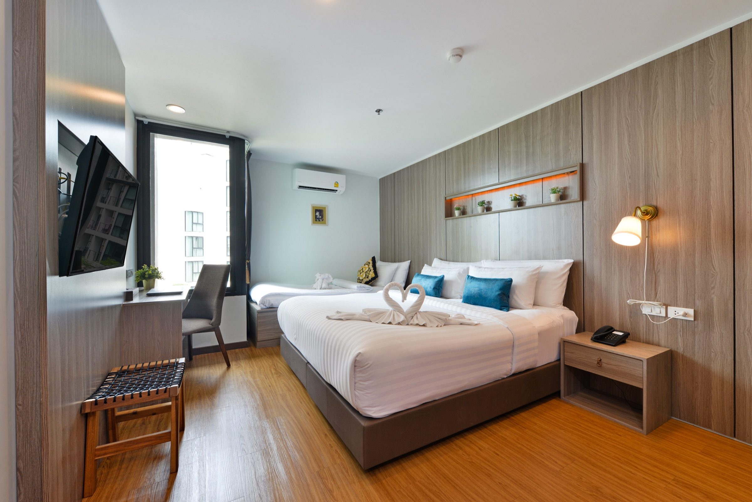 A Deluxe King room at StayAt Bedever set up with an extra bed