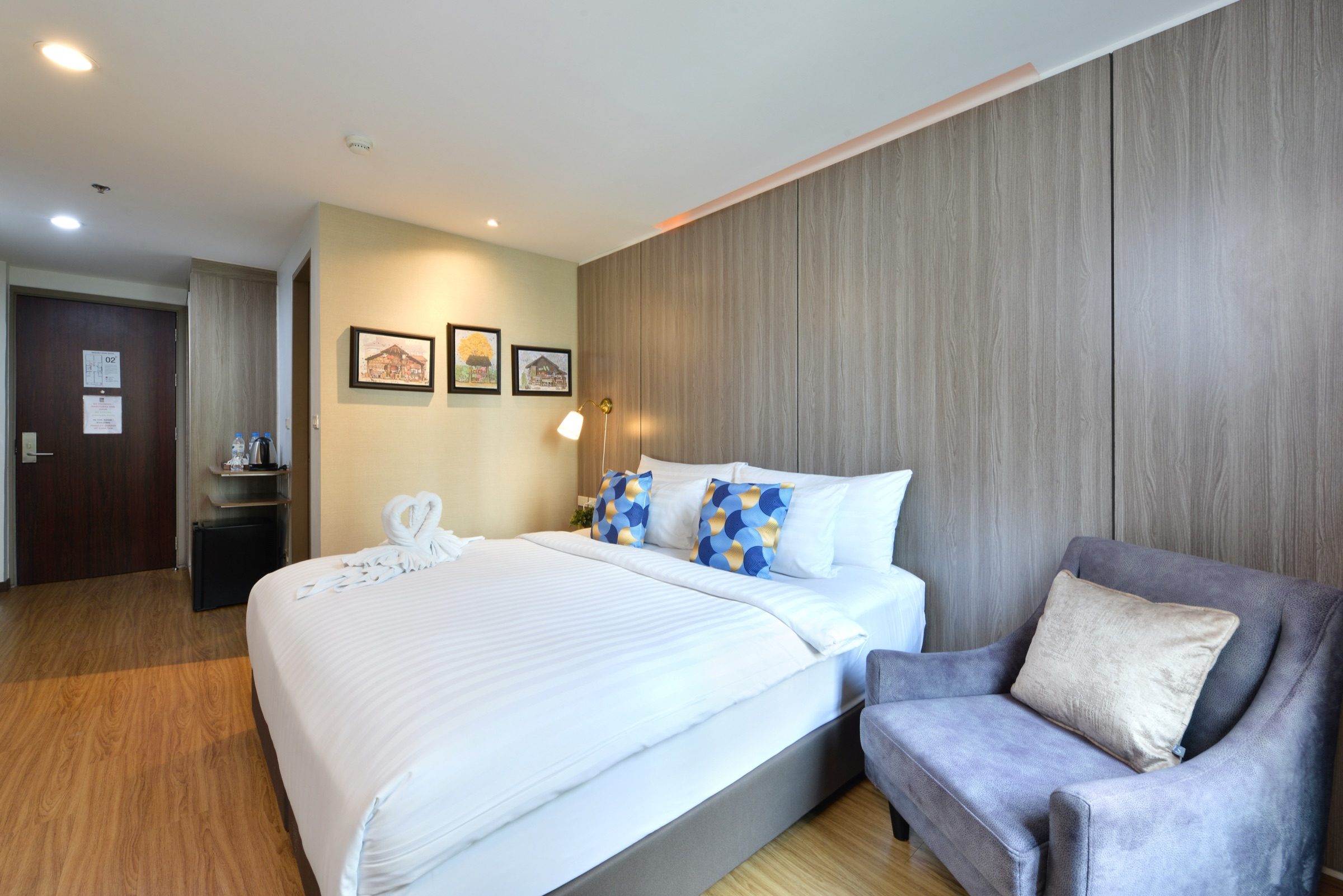 A king bed and a grey armchair in a Superior King room at StayAt Bedever