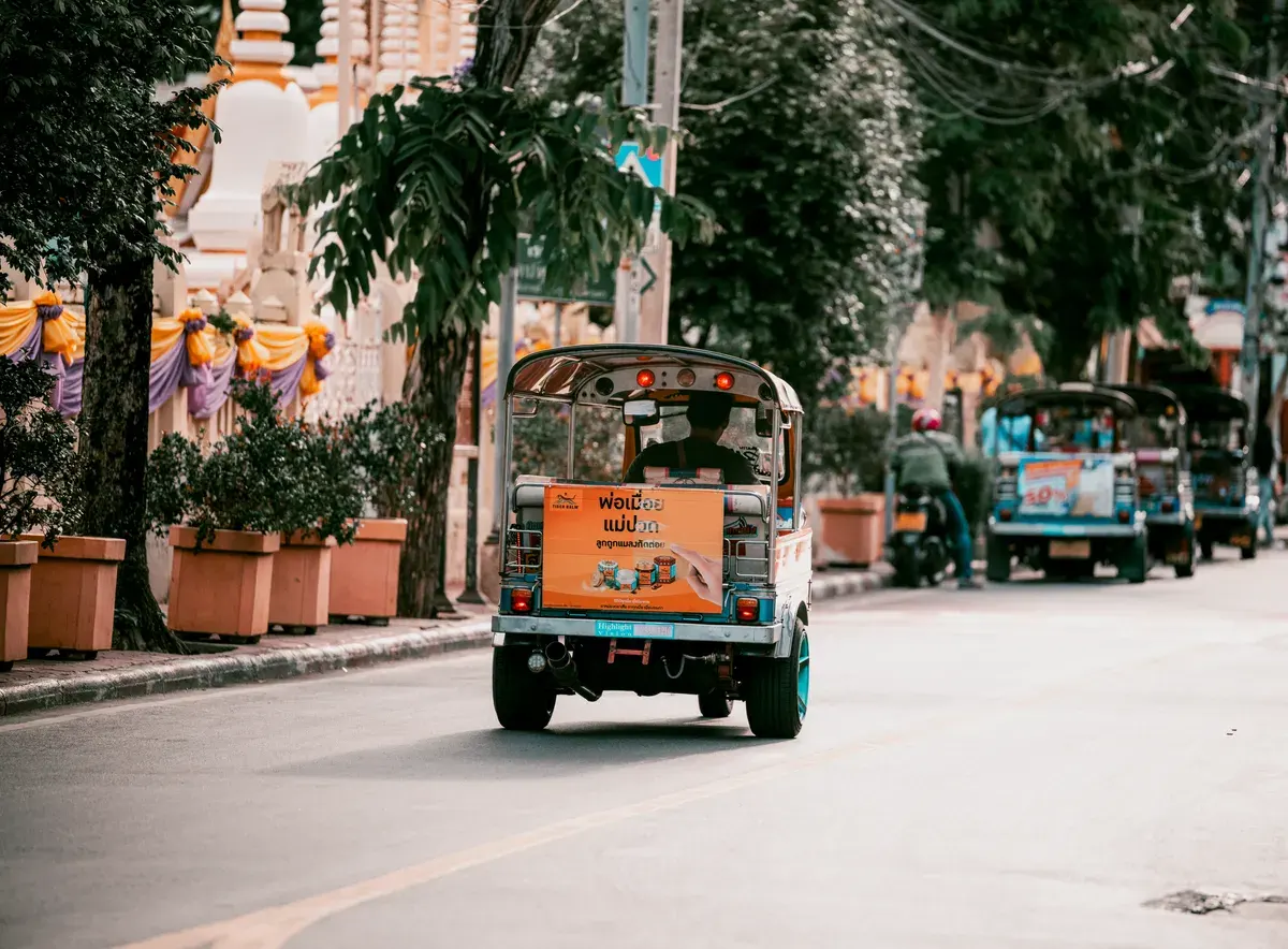 Vibrant Bangkok street filled with colorful tuk tuks showcasing urban transportation in Thailand.
