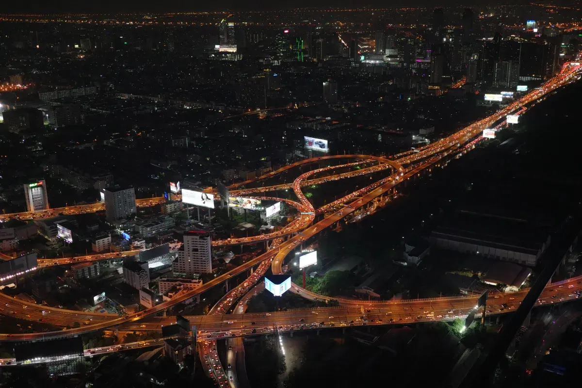 A stunning aerial view of Bangkok's illuminated expressways at night.