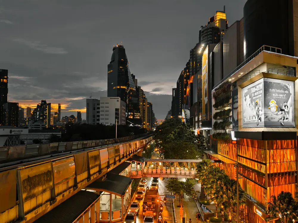 Twilight view of Bangkok's bustling cityscape with modern skyscrapers and illuminated streets.