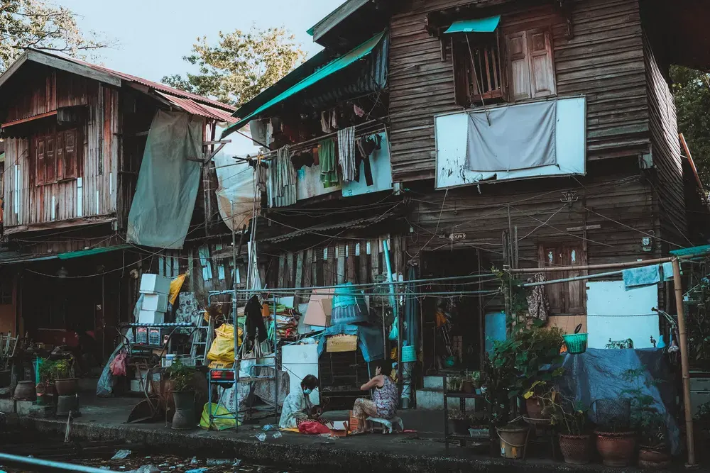 Rustic wooden houses in a Bangkok suburb, capturing daily life in a vibrant community setting.