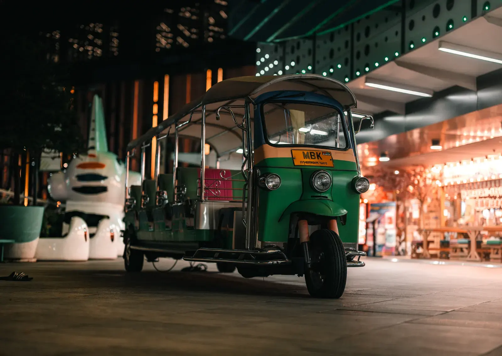 Vibrant tuk-tuk captured on a lively Bangkok street at night, showcasing iconic Thai culture.