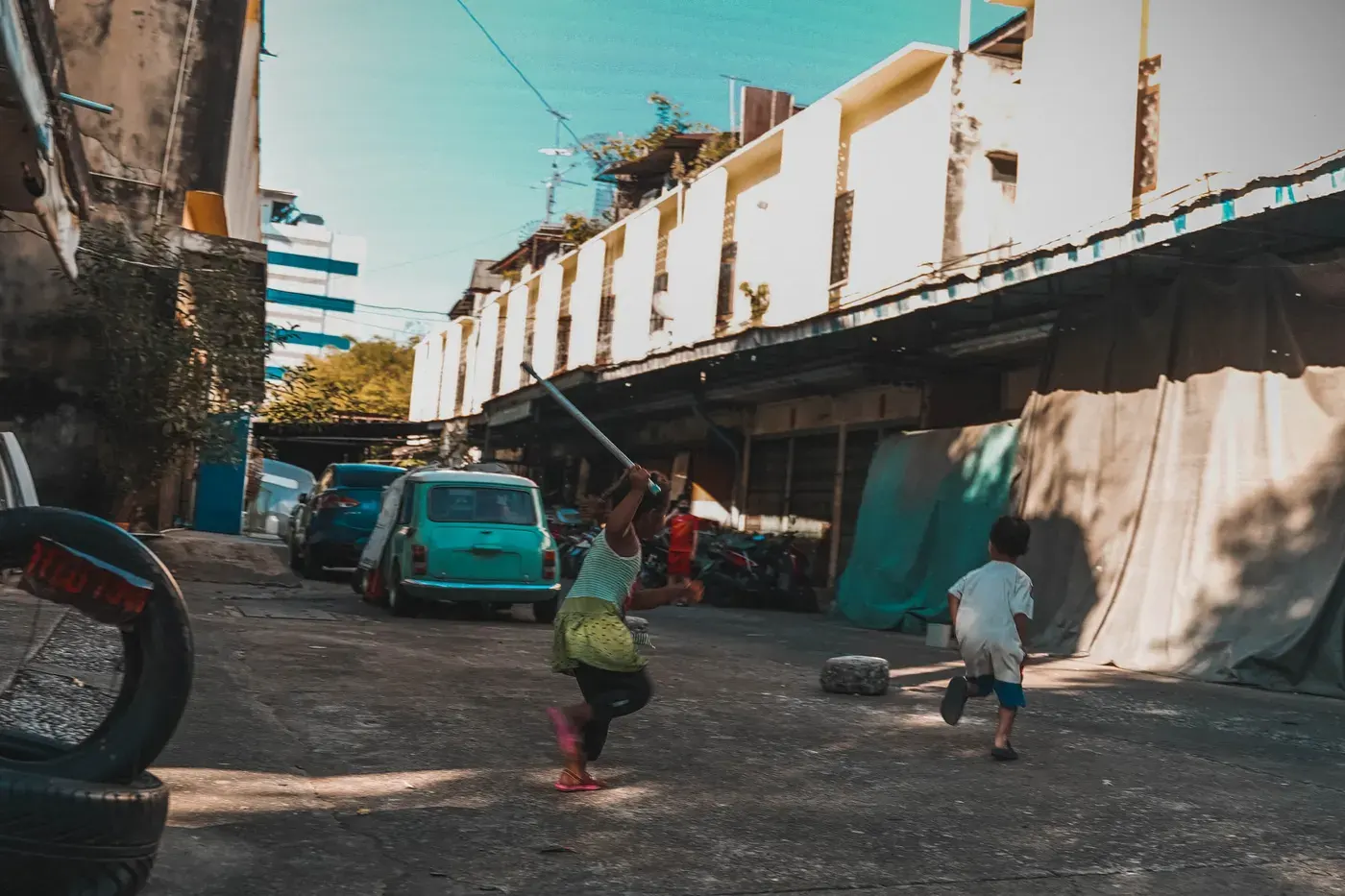 Kids running joyfully in a Bangkok suburb, capturing urban childhood adventures.